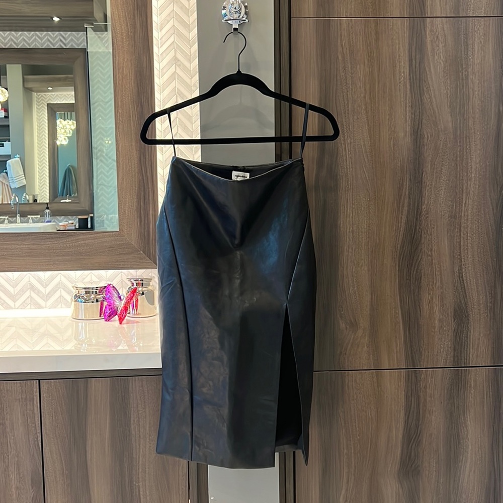 Super down black faux leather skirt with high slit.